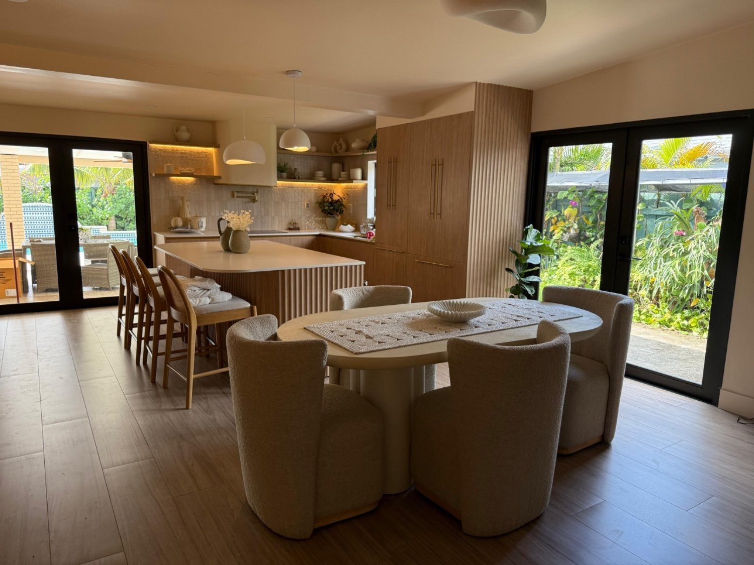 Warm dining room with bouclé chairs and oak kitchen